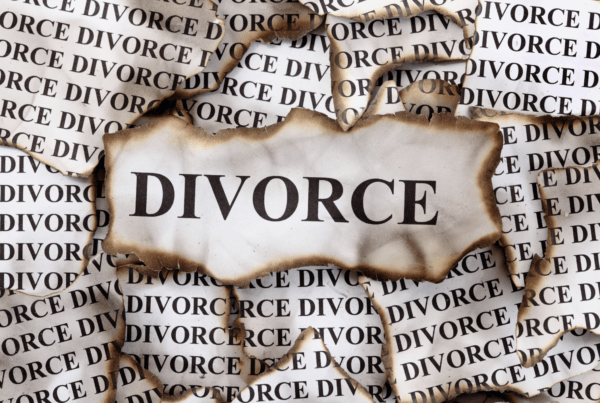 Burned paper with the word "Divorce" printed repeatedly, symbolizing the emotional and legal upheaval of divorce.