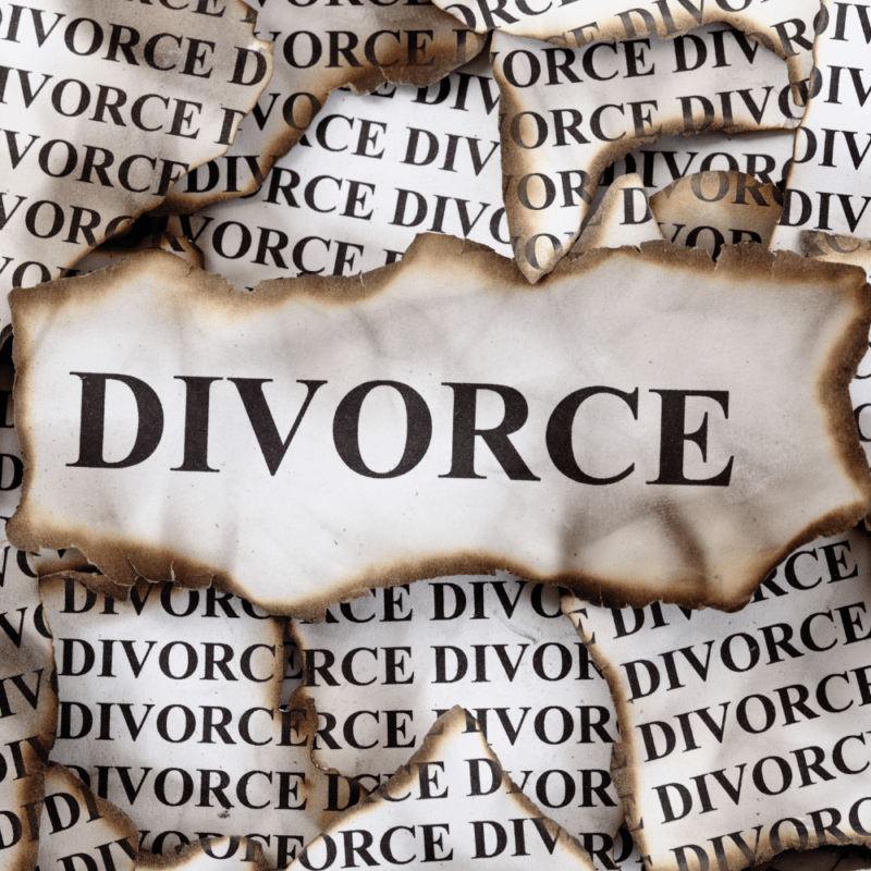 Burned paper with the word "Divorce" printed repeatedly, symbolizing the emotional and legal upheaval of divorce.