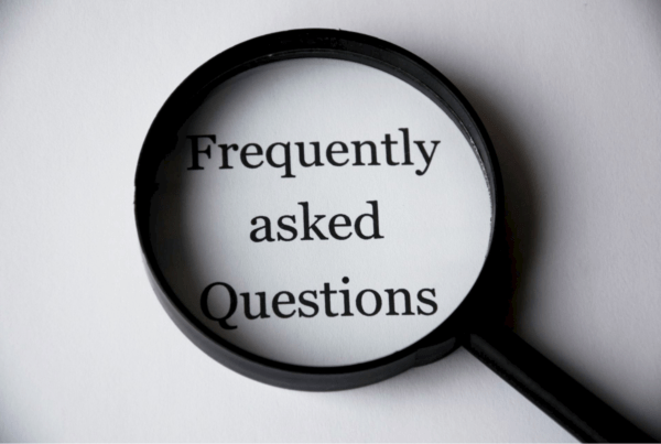 Magnifying glass over the words "Frequently Asked Questions" on a white background