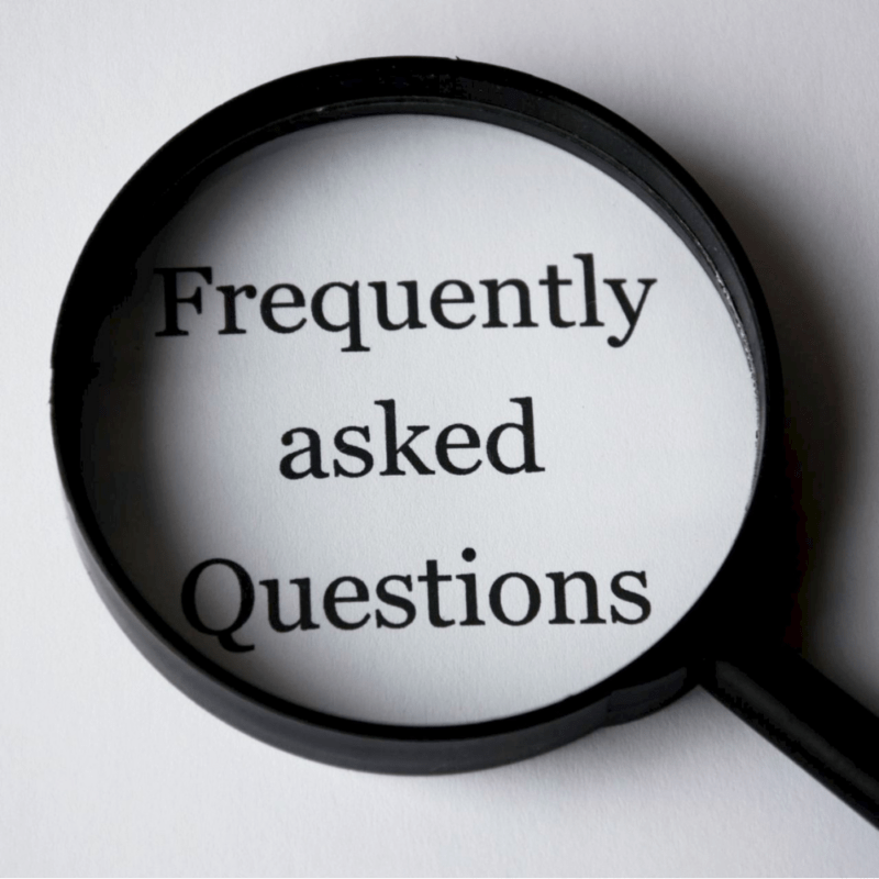 Magnifying glass over the words "Frequently Asked Questions" on a white background