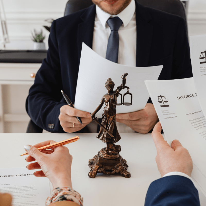 Divorce consultation with documents and Lady Justice statue in an attorney's office